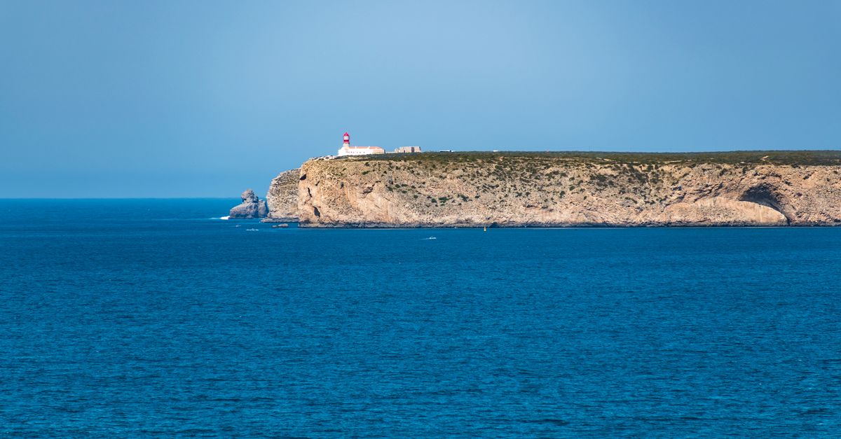 Rugged Algarve cliffs in ochre stone, a footpath running along the clifftop above